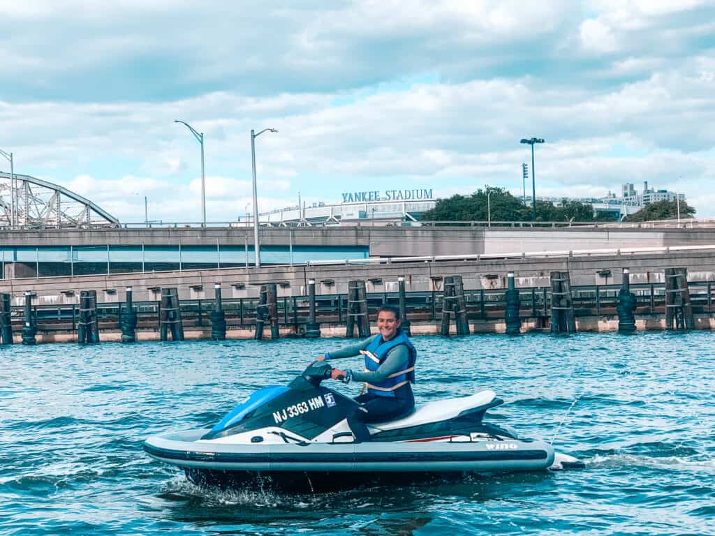man riding a jet ski in front Yankee Stadium